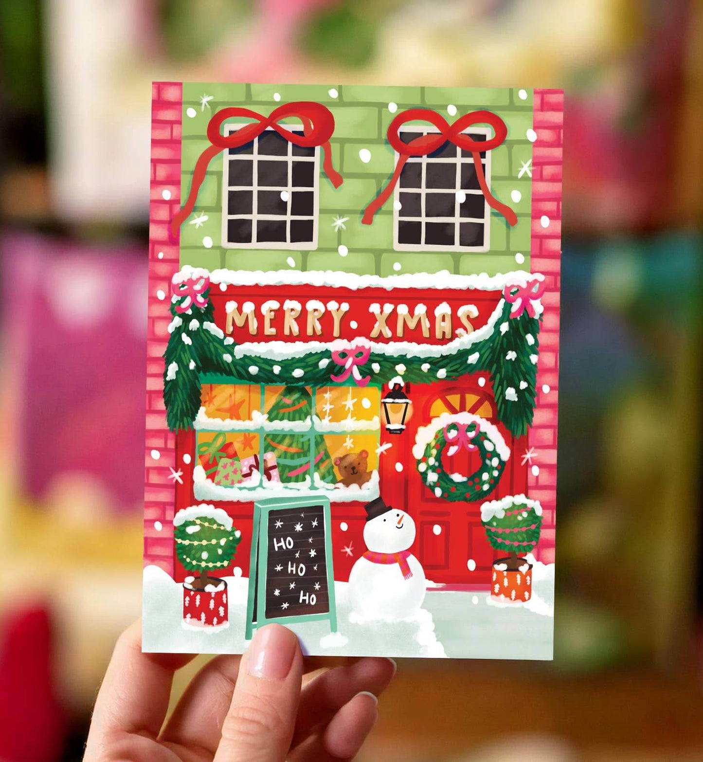 Aniet Illustration - Kerstkaart vrolijke kerst winkel merry Xmas met sneeuwpop - The Dreamer's Bookshop.
